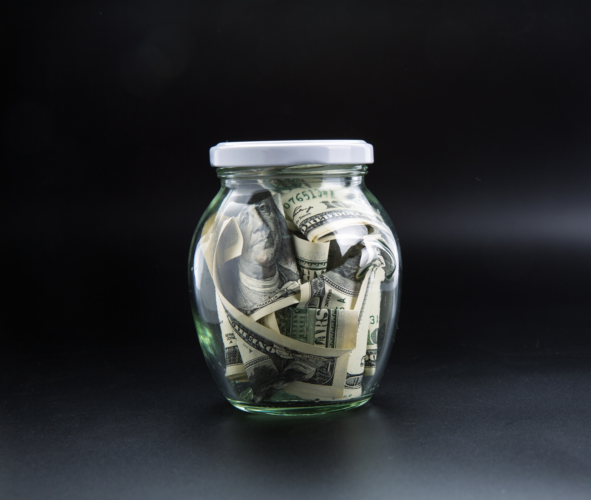 Money saving concept, glass jar full of dollars